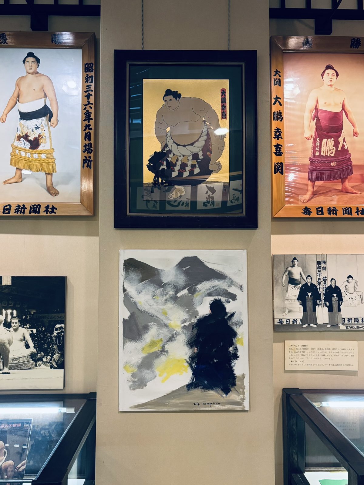 歴史的な力士の肖像と現代絵画が並ぶ記念館の壁