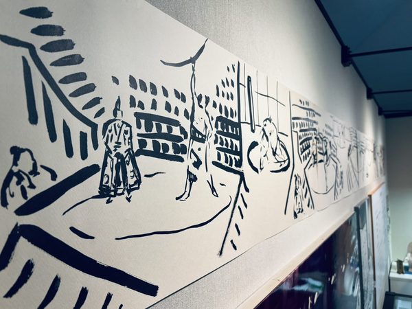 展示室の壁に沿って掛けられた横長の墨の巻物。行司、力士、相撲場の情景