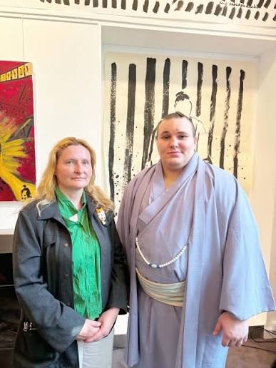 自身の墨画の前で力士・安青錦と並ぶゾヤ・スコロパデンコ