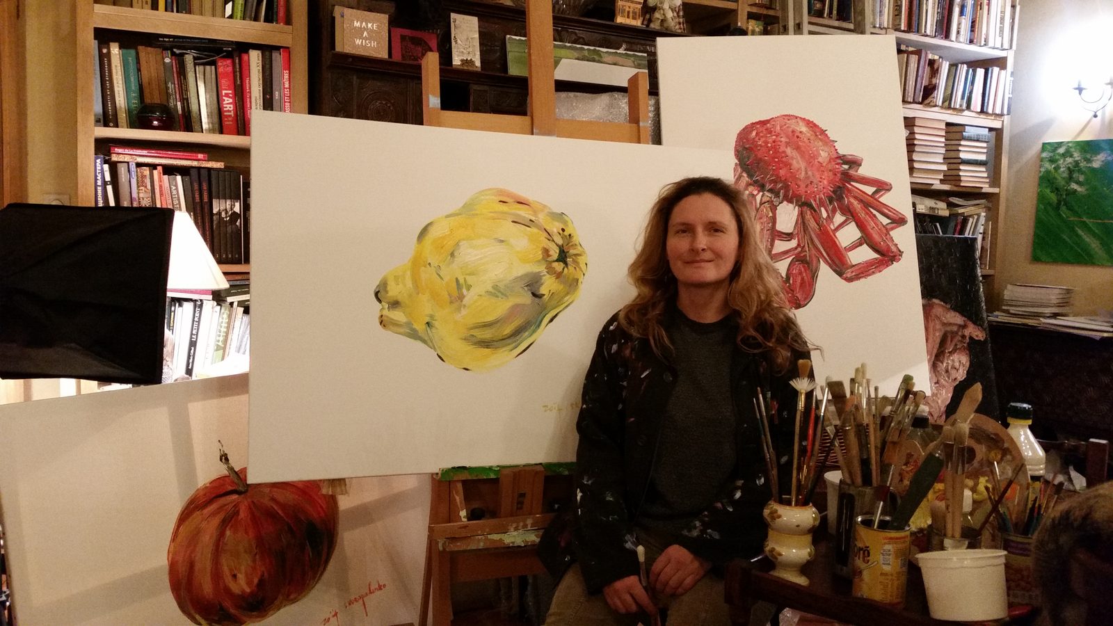アトリエで絵画と筆とともにいるゾヤ・スコロパデンコ